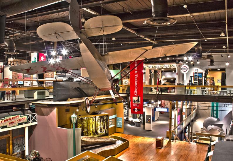 SC State Museum 4th floor exhibit gallery looking down onto the 3rd floor galleries with Clemson plane suspended from ceiling in foreground