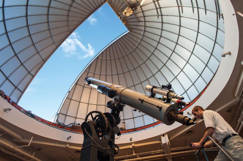 Observatory Educator Looks Through Alvan Clark Telescope During Solar Observing Hours With Dome Open Above Him Showing Blue Sky