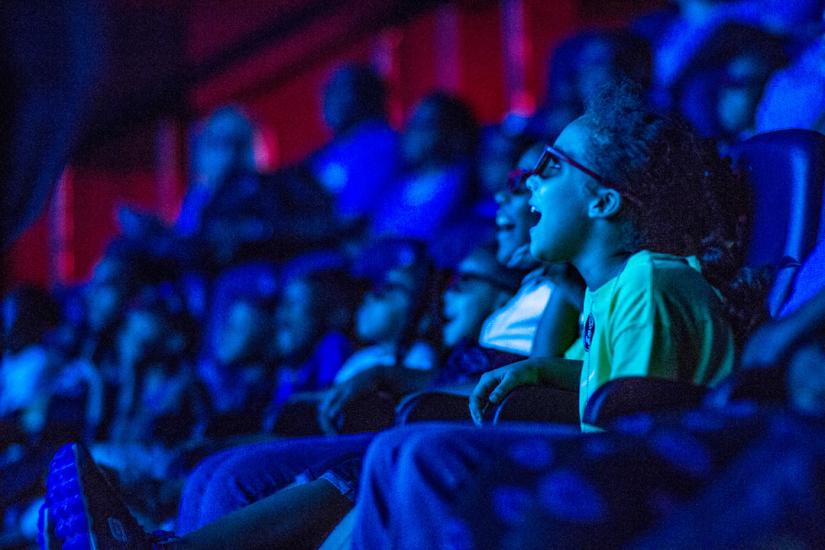 Young girl gasps in delight as she experiences a show in the in the 4D theater audience at the State Museum.