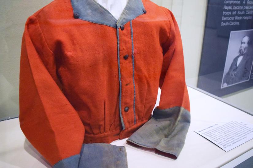 Red shirt with blue collar and cuff on exhibition in display case