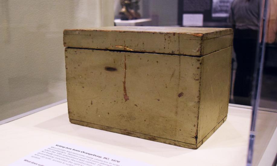 Rectangular, grayish colored box c. 1876 with hinged lid on exhibition