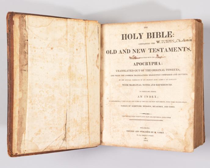 Large open, antique Bible with Title Page Showing includes black lettering and the words "Holy Bible"