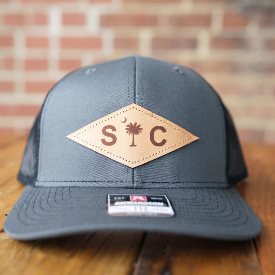 Baseball Cap with Dark Gray Front and Brown Leather Diamond Shaped Patch with Palmetto and Crescent and SC Lettering
