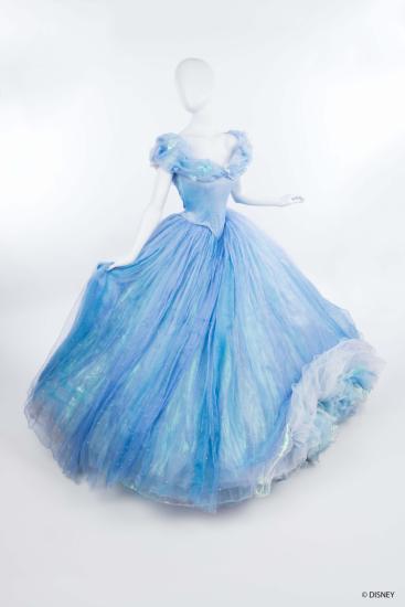Mannequin on white background wearing light blue off the shoulder ballgown with twirling skite in light blue layers of chiffon.